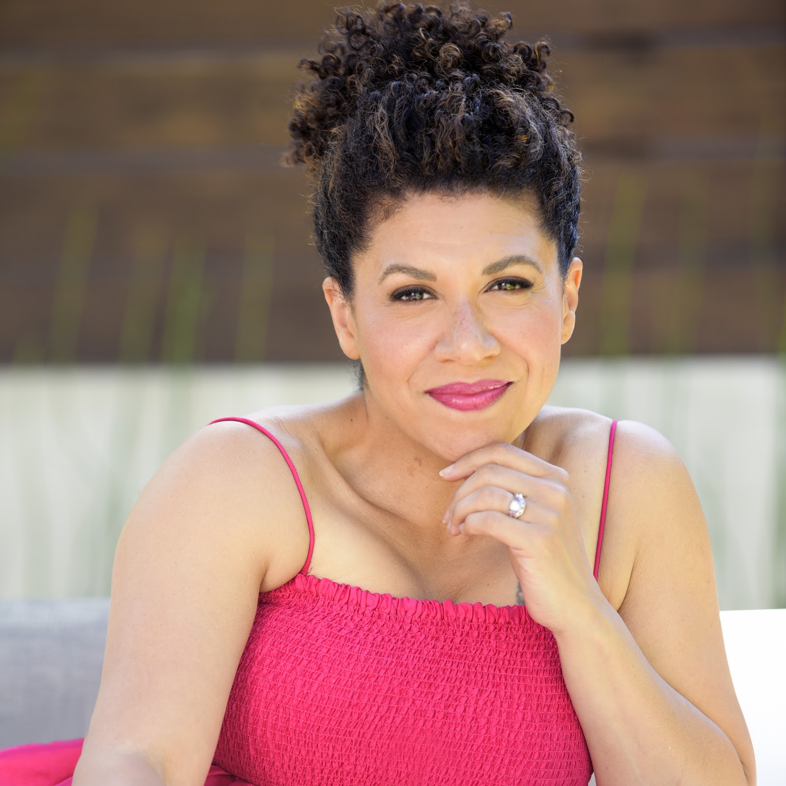 Damona Hoffman resting her chin on her hand, wearing a red top